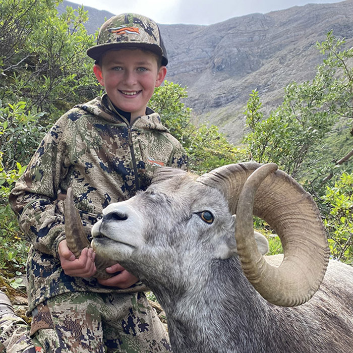 Young hunter with a bighorn ram.
